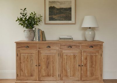 Woonkamer met teak dressoir Senja met vier deuren, decoratieve vaas en schilderij aan de muur.