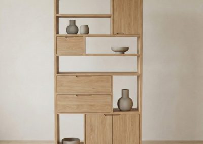 Studiofoto van teak boekenkast Arus met open vakken, laden en deurtjes, asymmetrische indeling en decoratieve objecten.