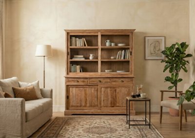 Woonkamer met beige bank, jute vloerkleed en teak kast Senja met open schappen en lades, met grote plant.